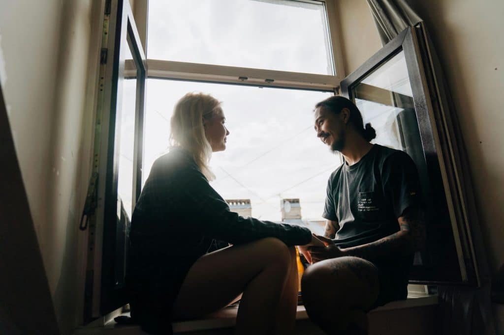 A man and woman sitting at the window