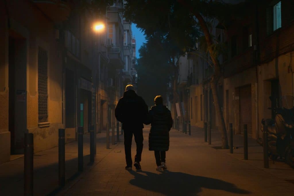 A man and woman walking outside at night 