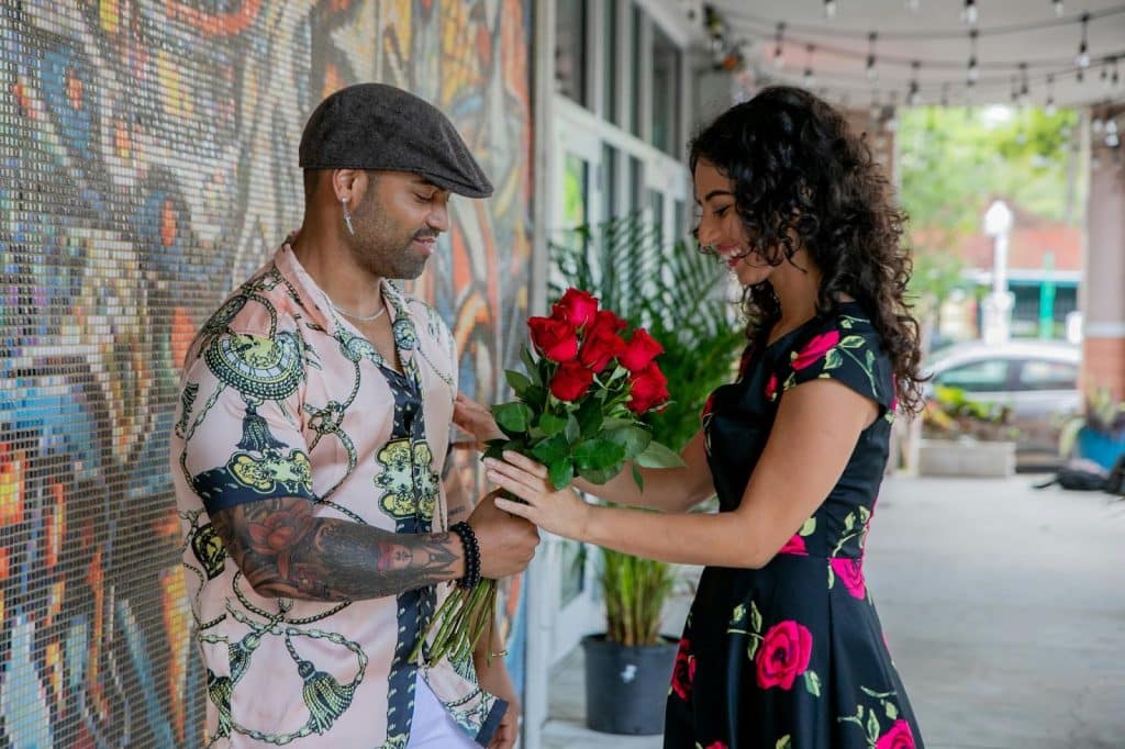A man giving a flower to a woman