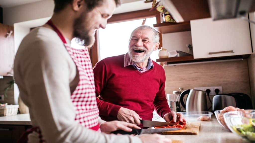 A dad and a son cooking in the kitchen.