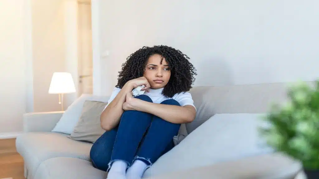 A woman looking sad at home.
