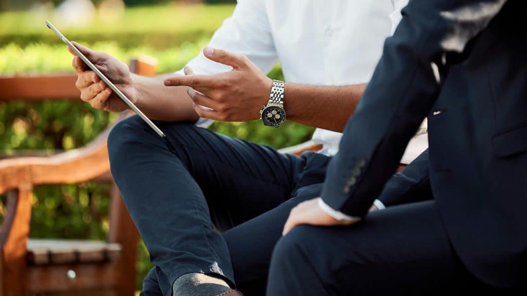 A close-up of two people in business attire looking at a tablet.
