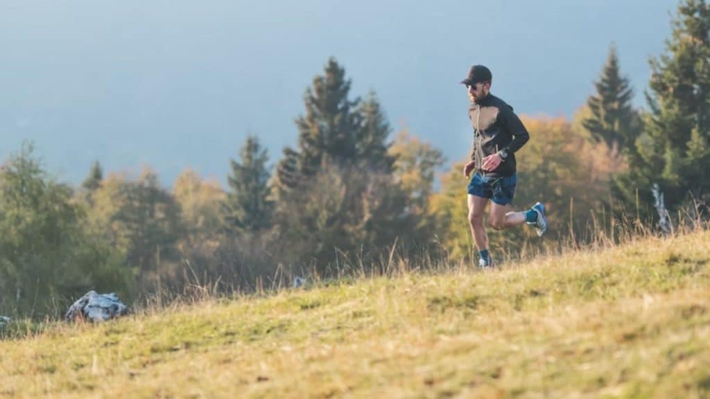 Man jogging along a riverside trail in early morning light