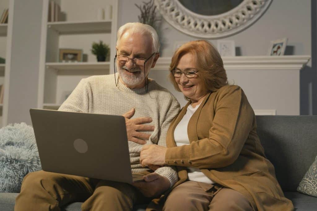 A man and woman watching at the laptop