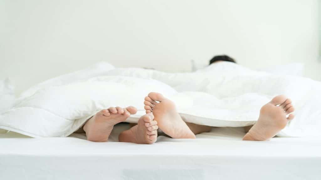 A couple’s feet in bed
