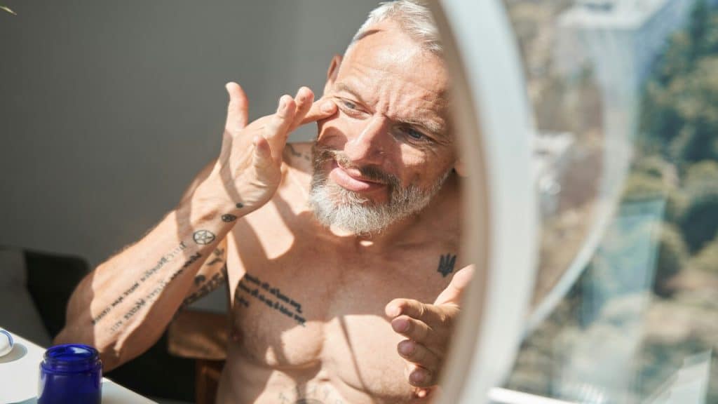 An older man looking at himself in the mirror