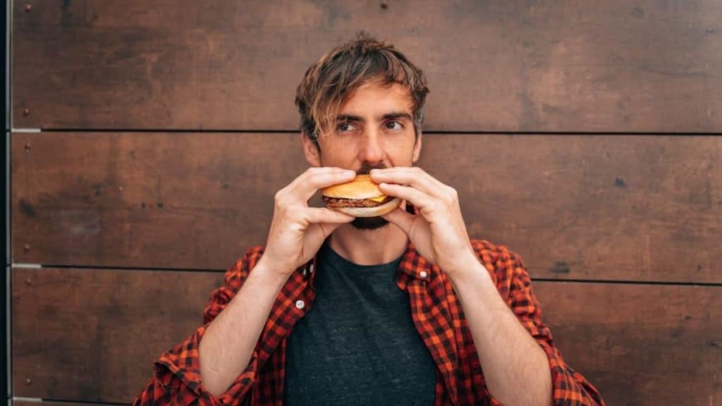 Man feeling physically weak because of eating unhealthy food