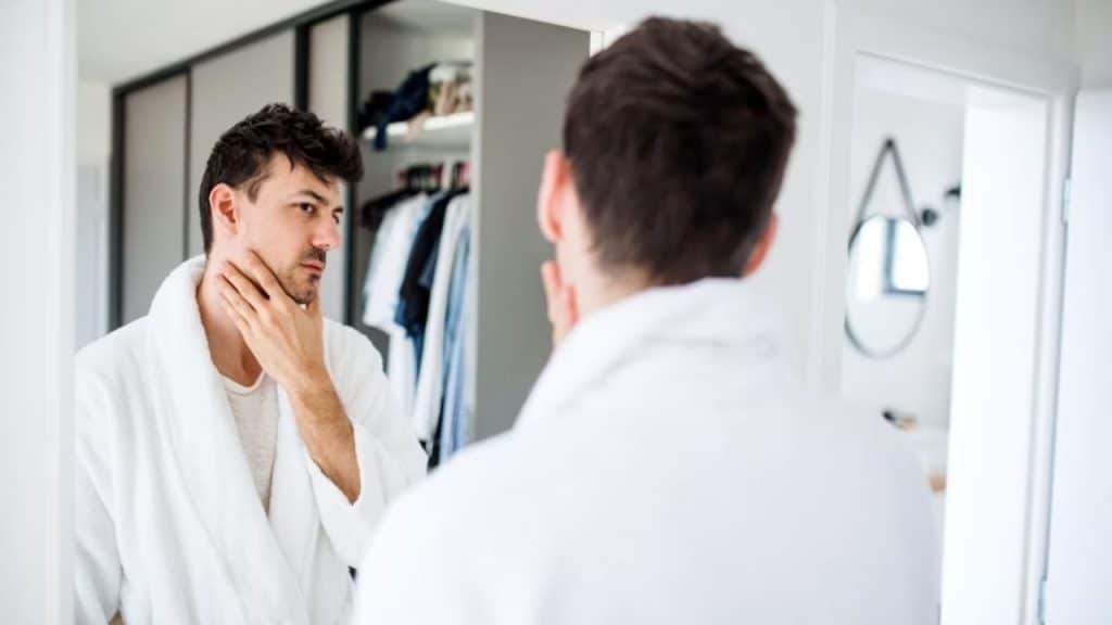 Man reflecting in front of a mirror.