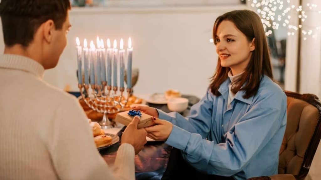 Couple exchanging gift at a candlelit table