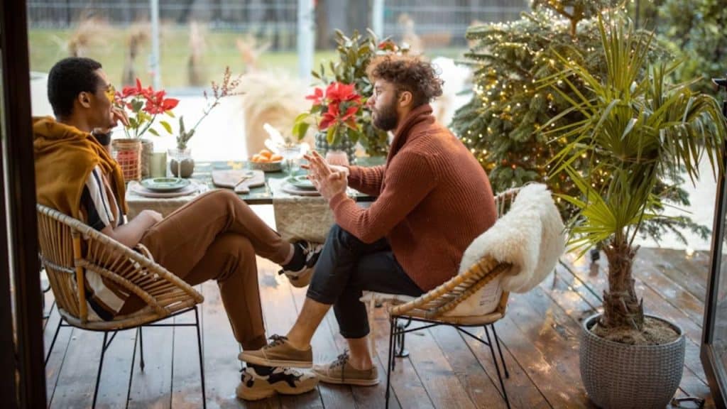 Man sitting at a café listening to a friend complain about marriage