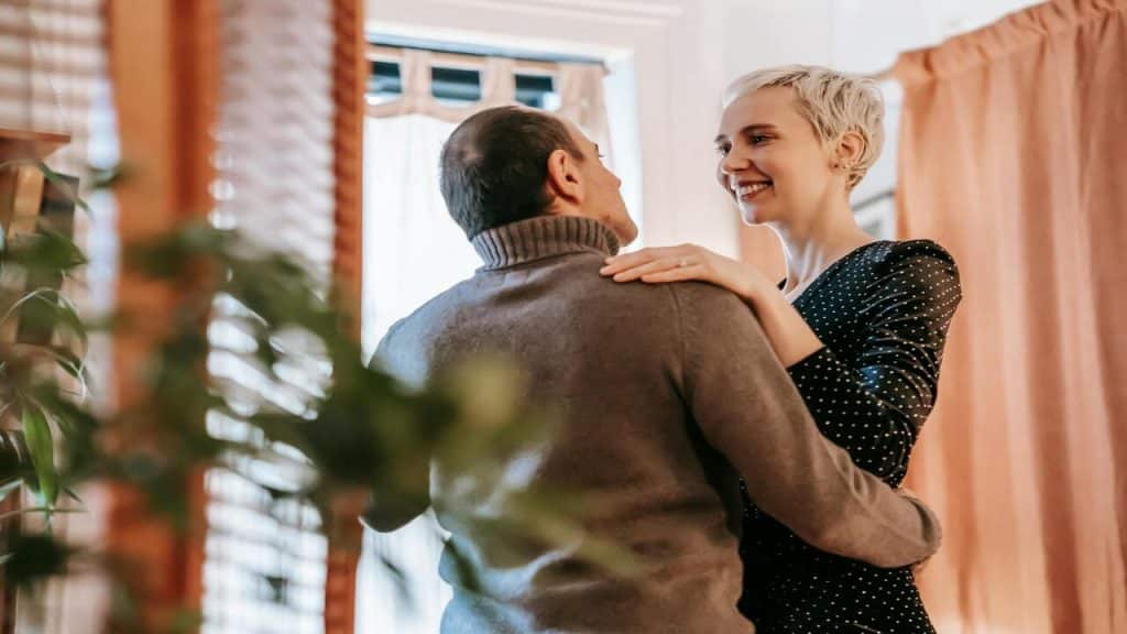 A couple talking while dancing at home