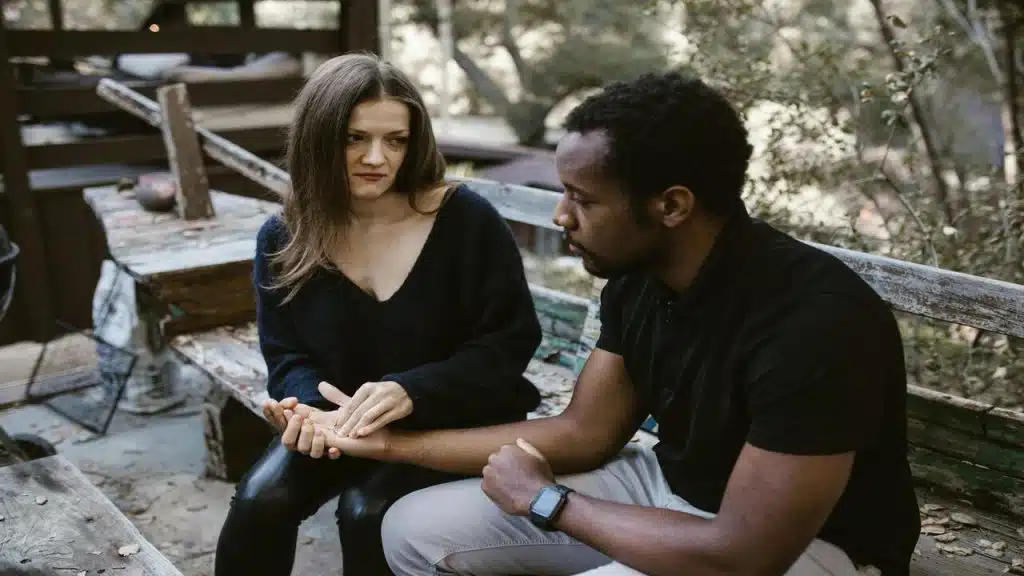 A woman crying in front of her nonchalant husband