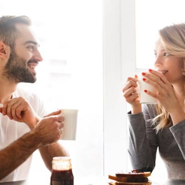 A man and a woman having a conversation over a cup of coffee