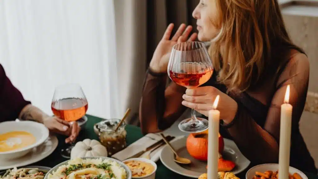 Woman raising her arms defensively at dinner