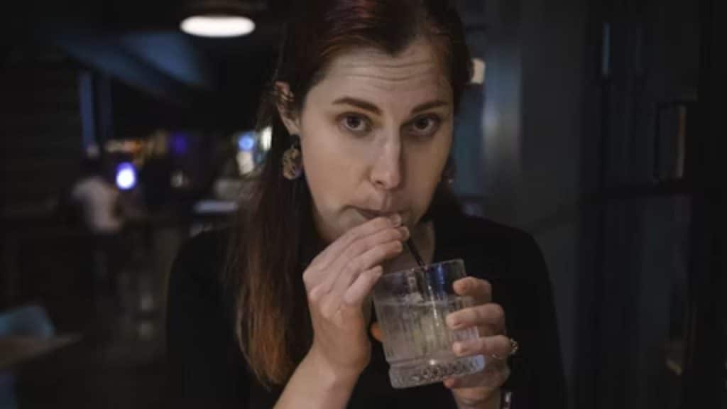 Woman drinking water looking annoyed