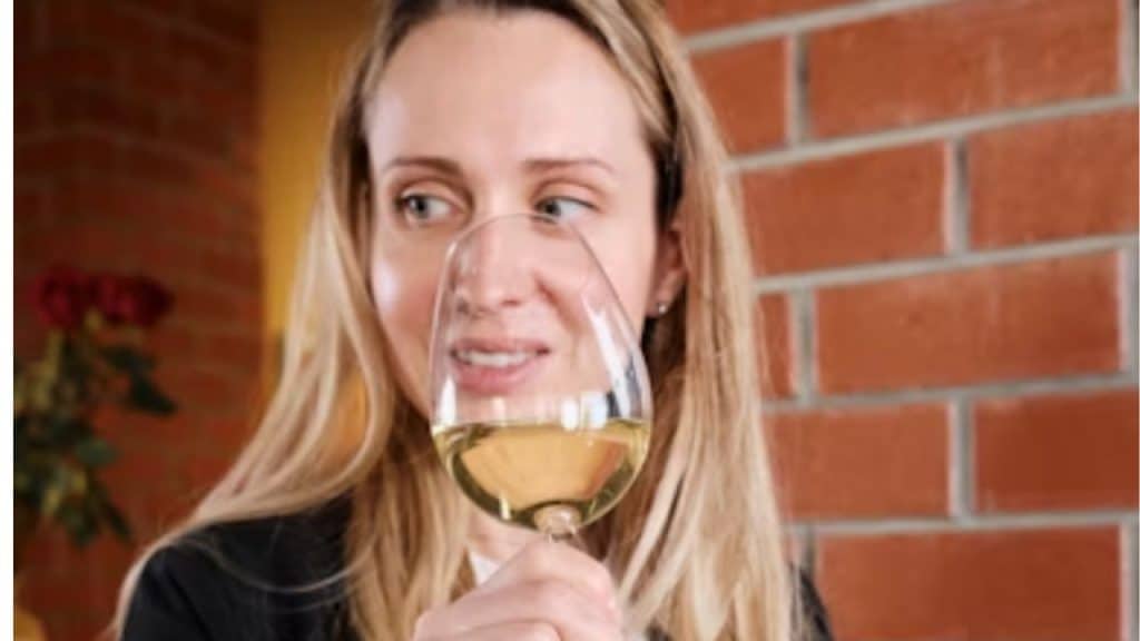 Woman giving a cautious look while sipping wine