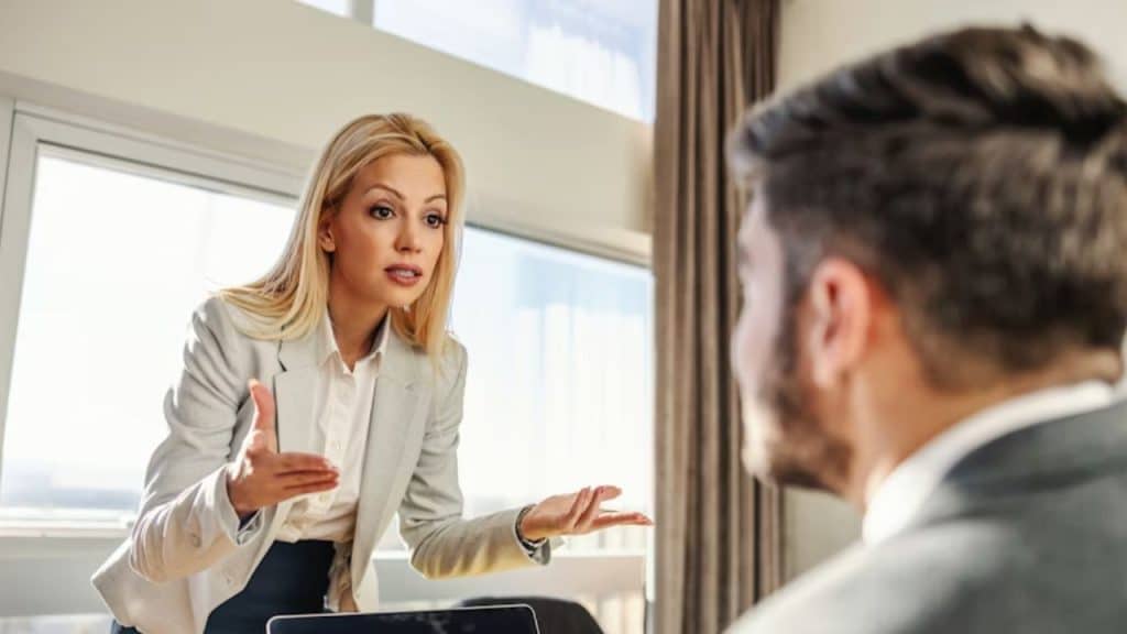 Woman looking shocked raising her both hands in disappointment