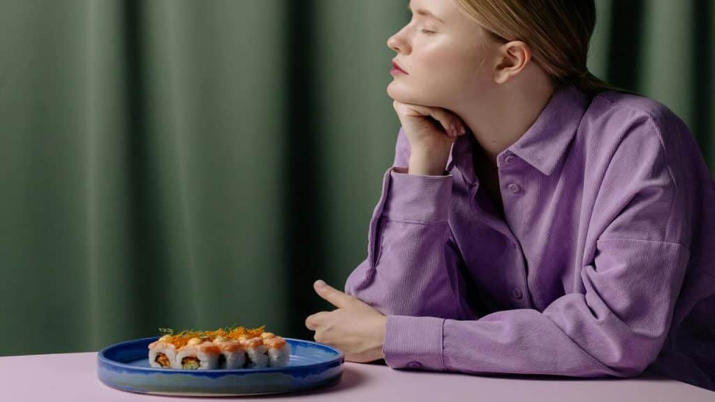 A woman ignoring the food in front of her