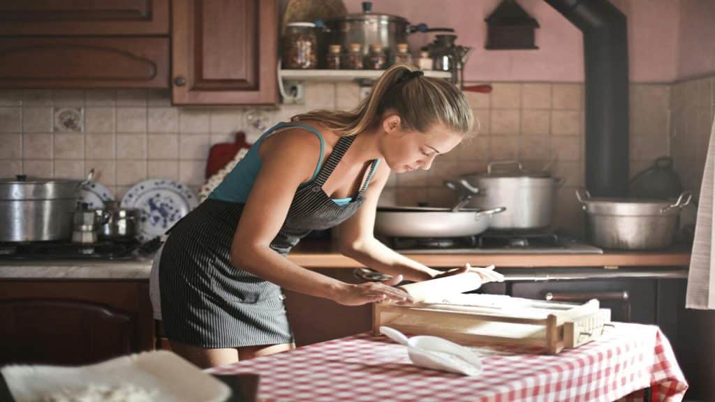 A woman rolling dough in the kitchen