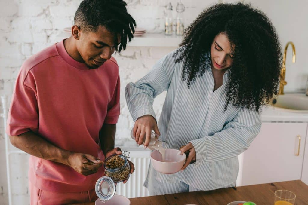 A man and woman preparing breakfast