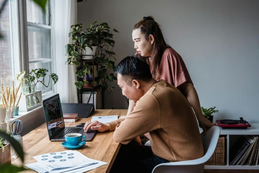 A man and woman looking at the laptop