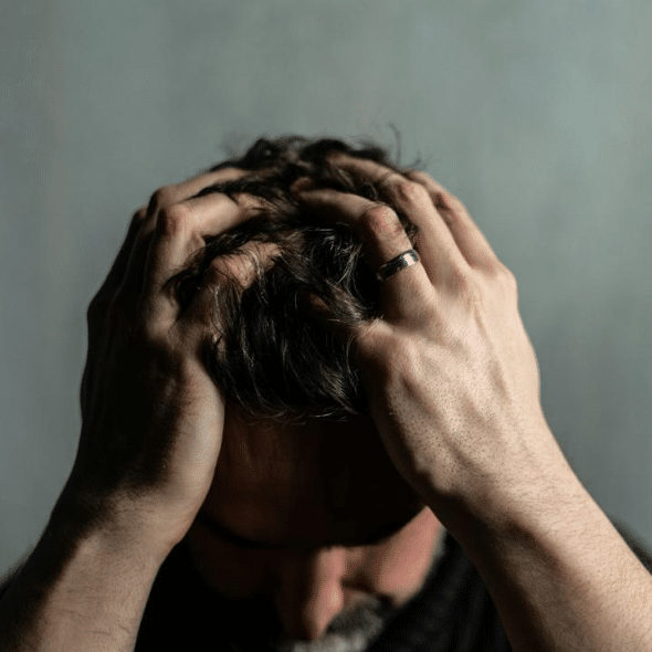 A man holding his head in his hands in frustration or stress.