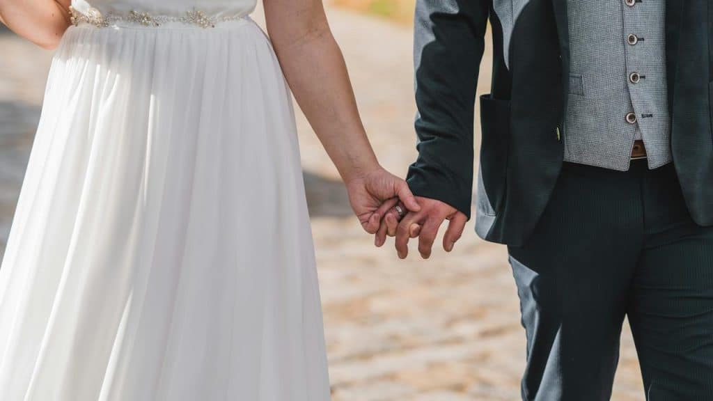 A bride and groom holding hands.