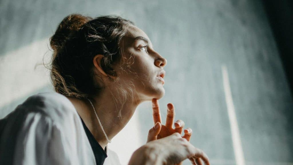 A woman looking thoughtful while gazing upward.