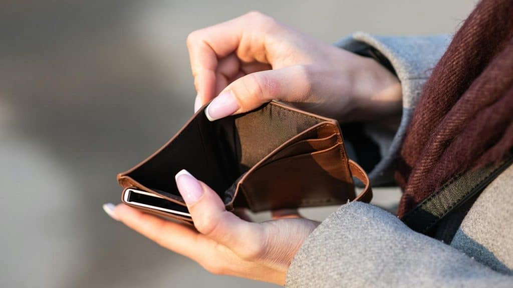A person holding an empty wallet.