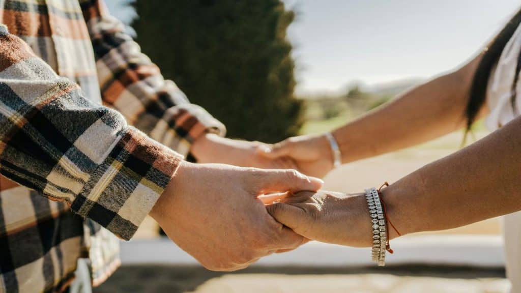 A couple holding hands outdoors.