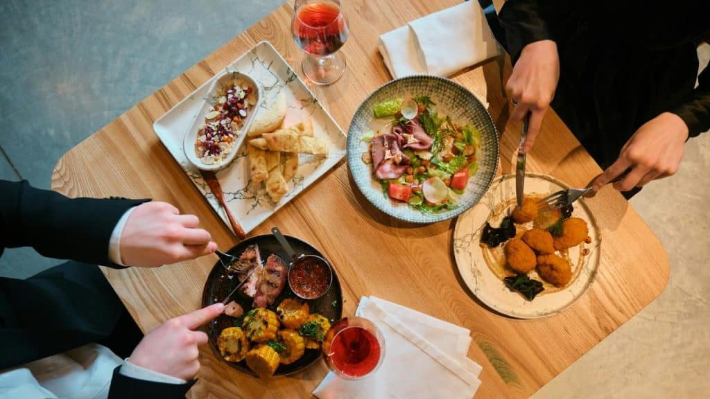 A table with various dishes and drinks being shared.