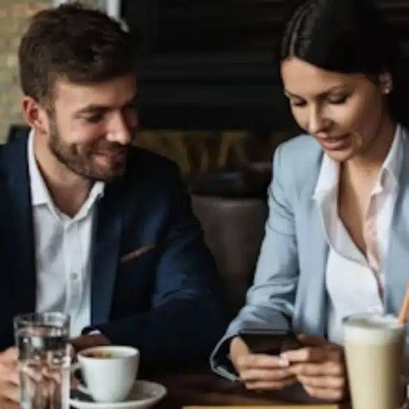 Woman scrolling on her phone while man waits at the table