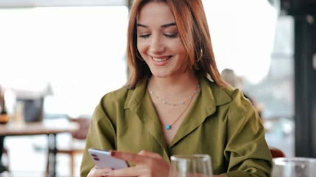 Woman busy with her phone at the dinner table
