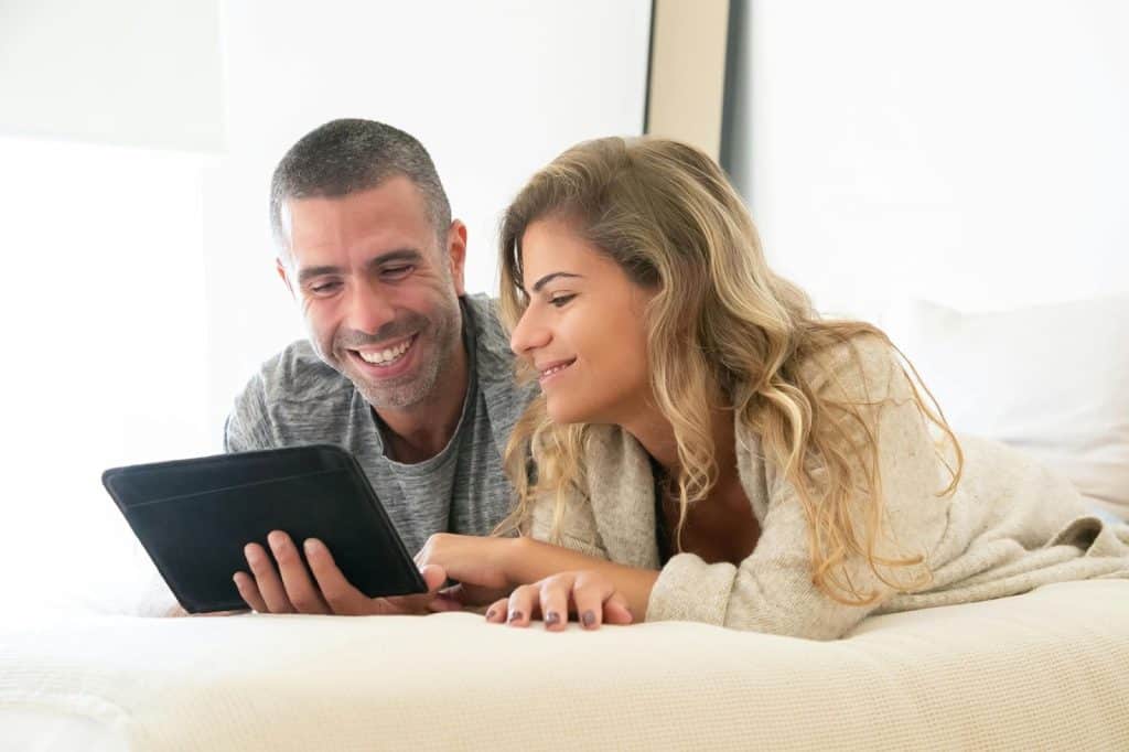 A man and woman holding a tablet 