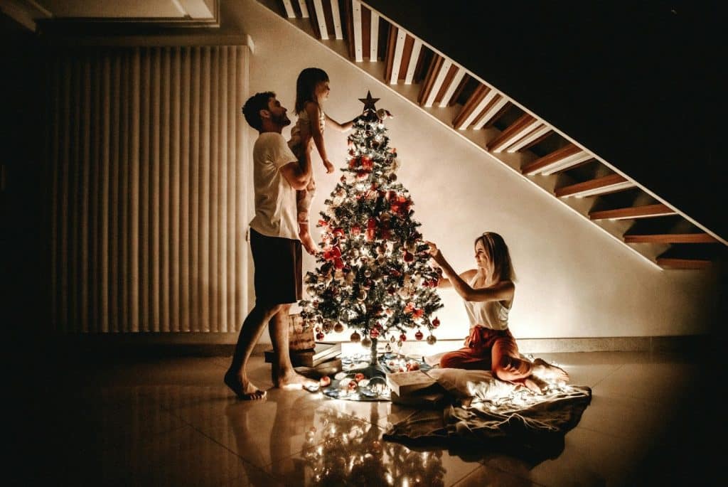 A man and woman decorating christmas tree