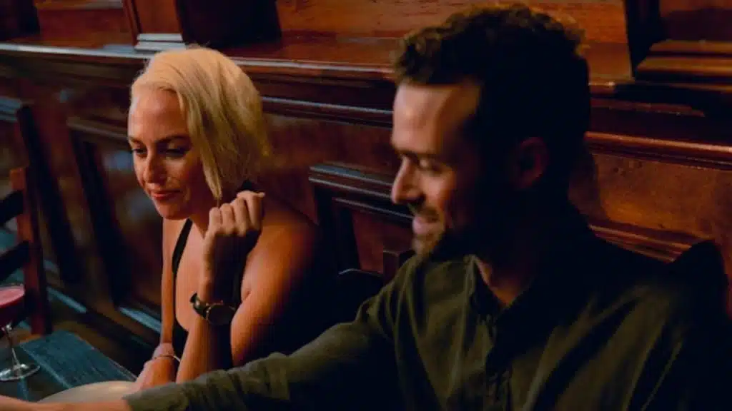Woman criticizing man at the dinner table while he stays quiet and smile