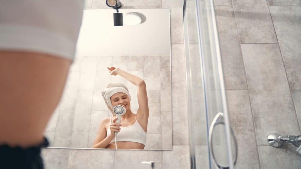 A woman singing in front of the mirror