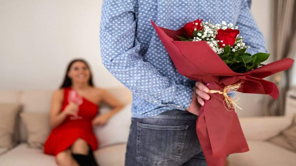 A man surprising his date with a bouquet of flowers