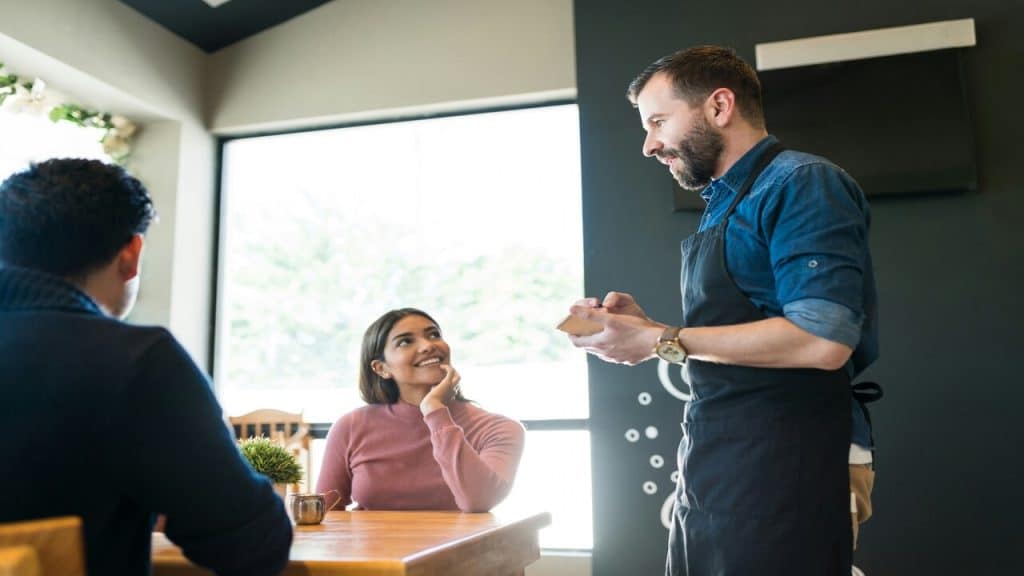 A waiter taking orders from a couple