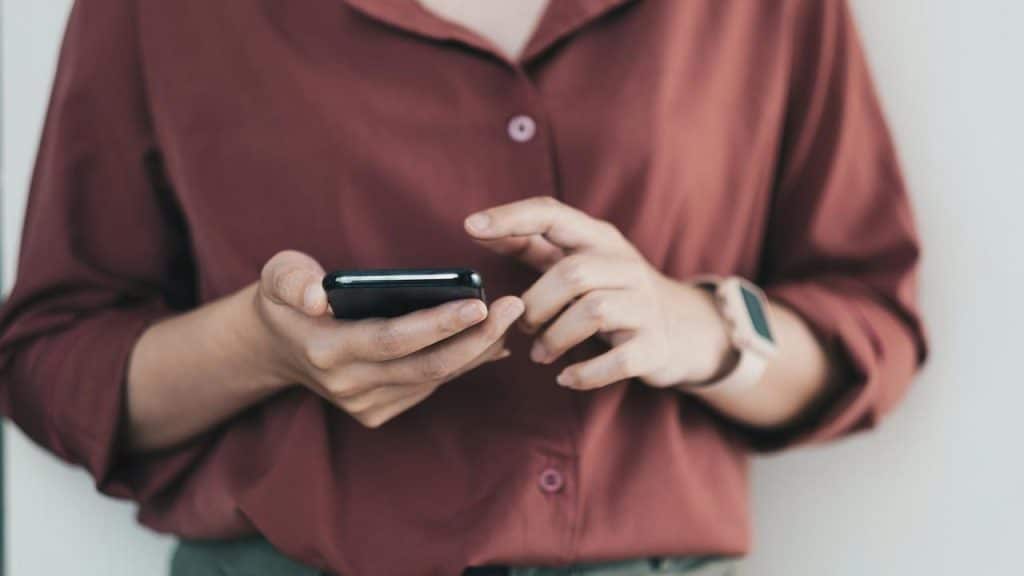 A person holding and using a smartphone.