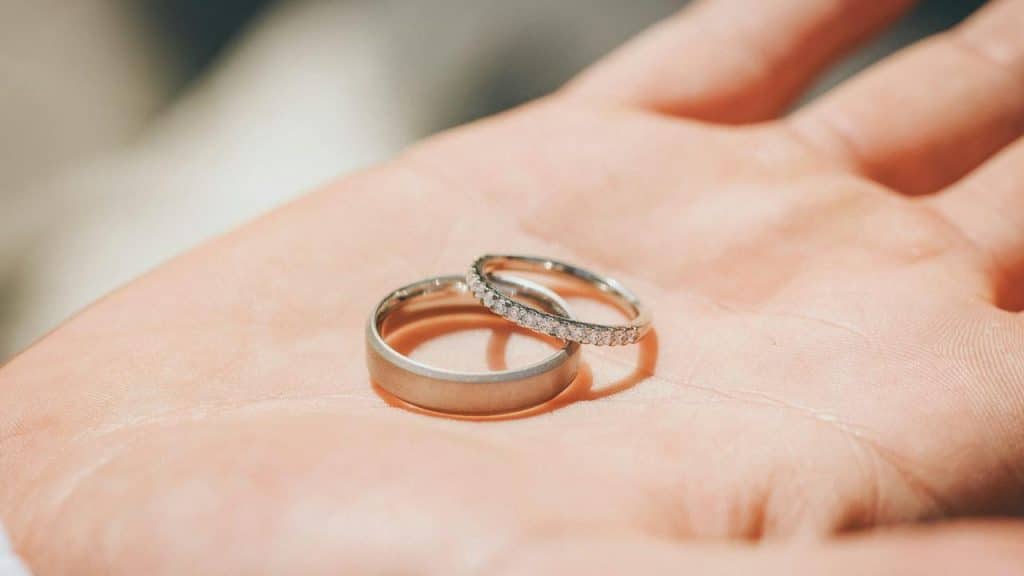A close-up of two wedding rings on a person’s hand.