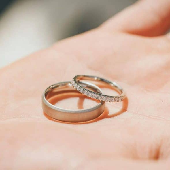 A close-up of two wedding rings on a person’s hand.