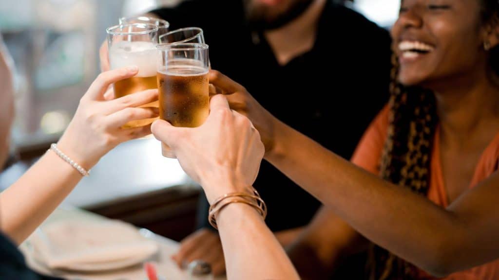 A group of people raising their glasses of beer together.
