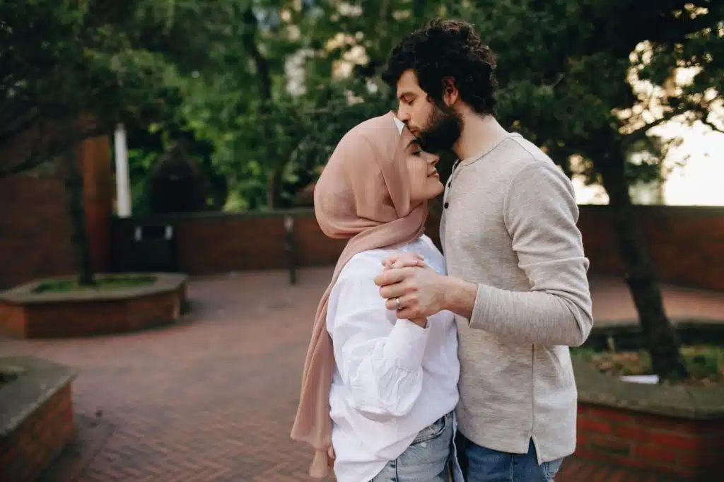 A man kissing a woman’s forehead