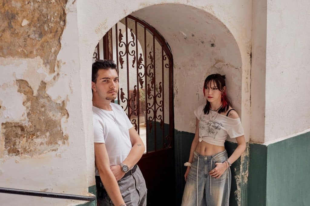 A man and woman leaning at the door frame