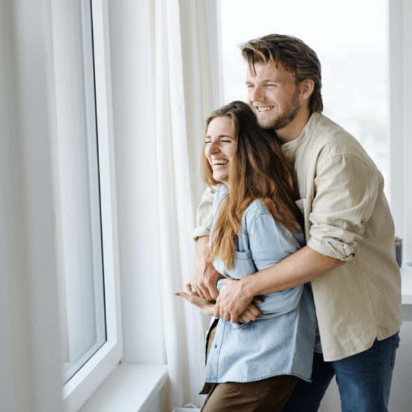 A couple laughing indoors
