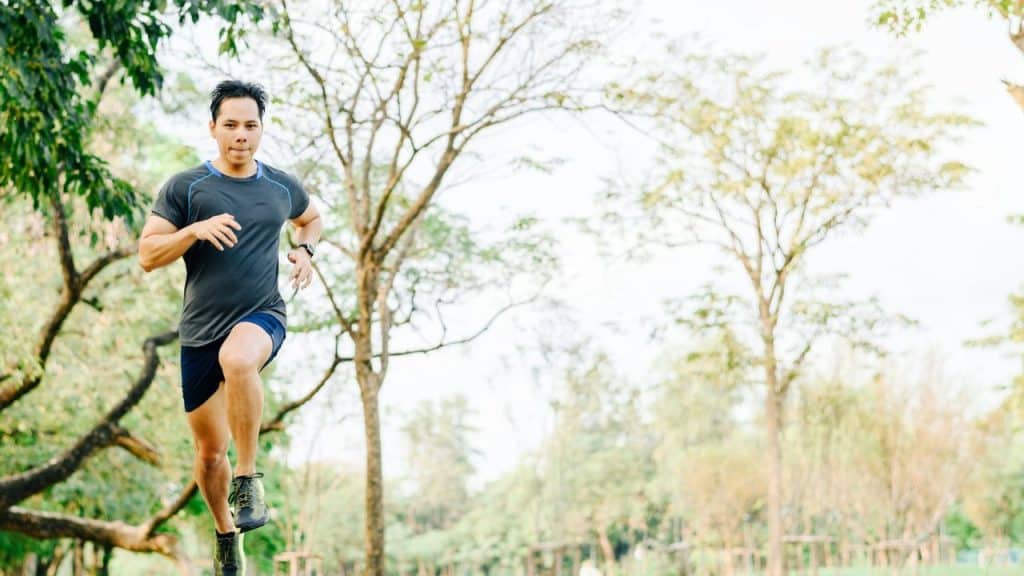 A person in athletic clothing is jogging through a park.