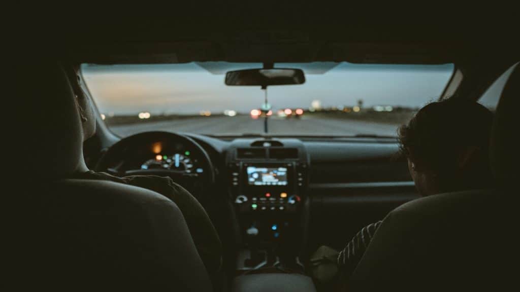 A couple choosing music in the car