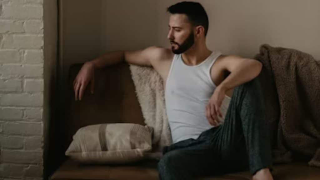 A man sitting on a couch, looking lost in thought