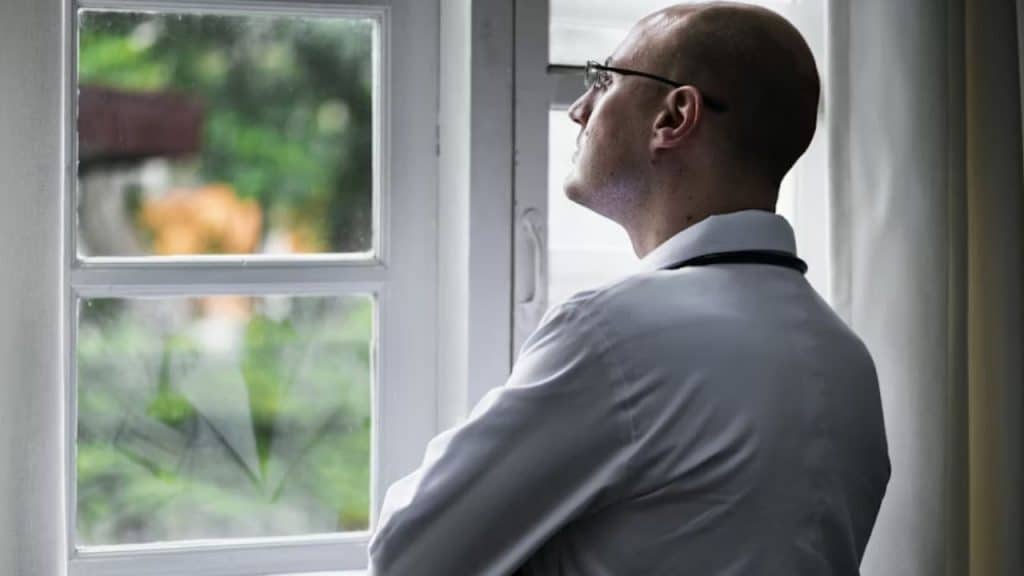Man staring out the window, lost in thought